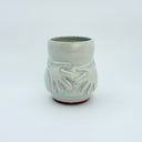 White ceramic cup with hand patterns on a white background