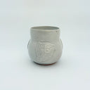 White ceramic cup with a bird design on a white background