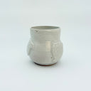 White ceramic cup with bird designs on a white background
