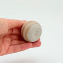 Hand holding a Kleybird Strata mini vase with striped clay bands.
