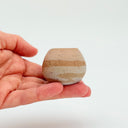 Hand holding a Kleybird Strata mini vase with striped clay bands.