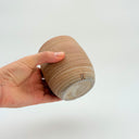 Kleybird Strata handleless tumbler with marbled clay exterior and light aqua interior held in hand.