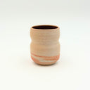 A small hand-thrown ceramic espresso cup with a marbled stoneware exterior and a dark plum glazed interior